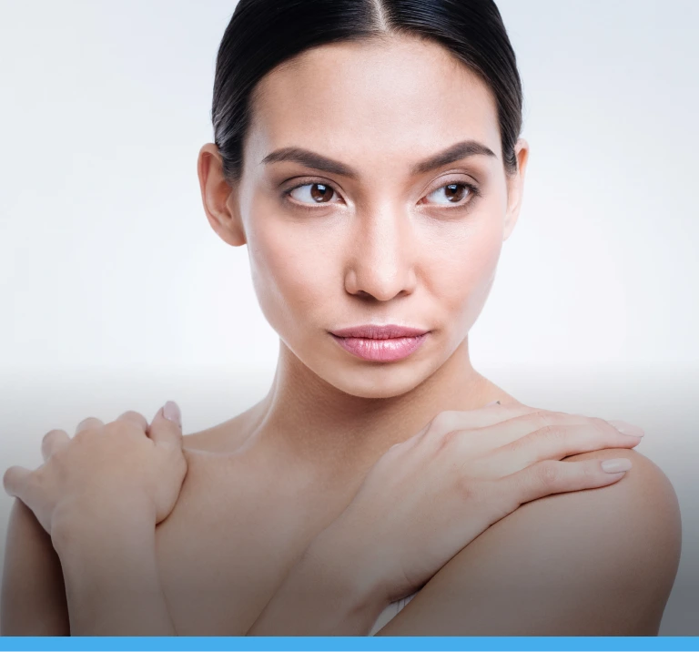 Woman with clear skin touching her shoulder, demonstrating skincare results
